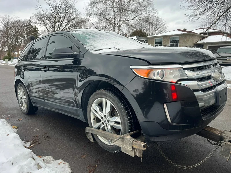 Damaged SUV hooked up to a tow truck for scrap car removal in Brampton, Ontario